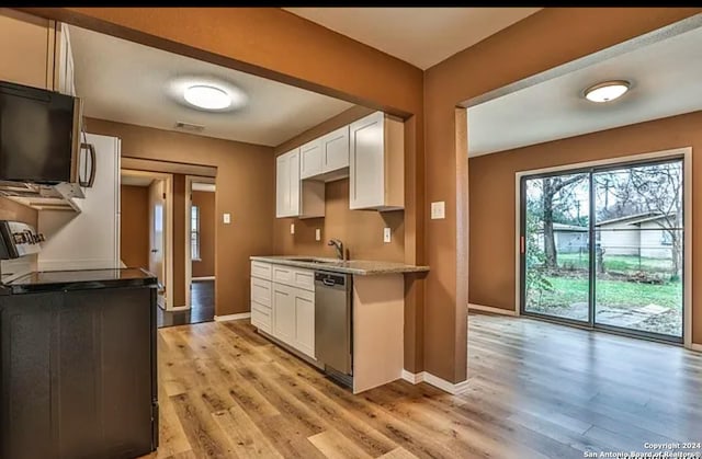 kitchen featuring light hardwood / wood-style floors, white cabinetry, sink, and dishwasher