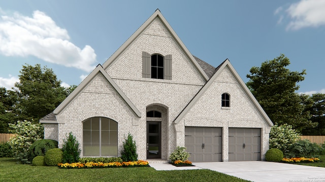 french country style house featuring driveway, a front yard, a garage, and brick siding