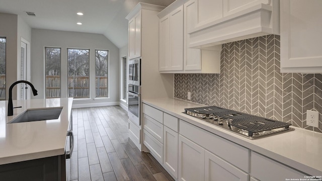 kitchen featuring a sink, appliances with stainless steel finishes, light countertops, recessed lighting, and white cabinetry