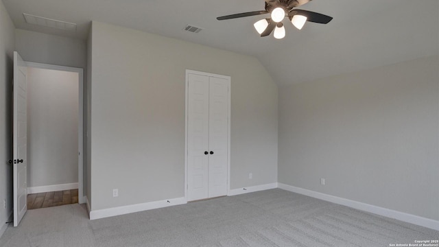 unfurnished bedroom featuring carpet flooring, a closet, baseboards, lofted ceiling, and ceiling fan