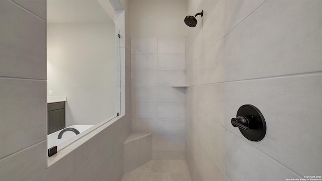 bathroom with a tile shower and vanity