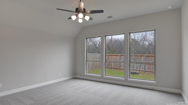 carpeted empty room featuring baseboards, plenty of natural light, ceiling fan, vaulted ceiling, and a smoke detector