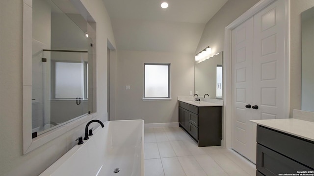 bathroom featuring tile patterned flooring, a bath, a stall shower, baseboards, and vanity