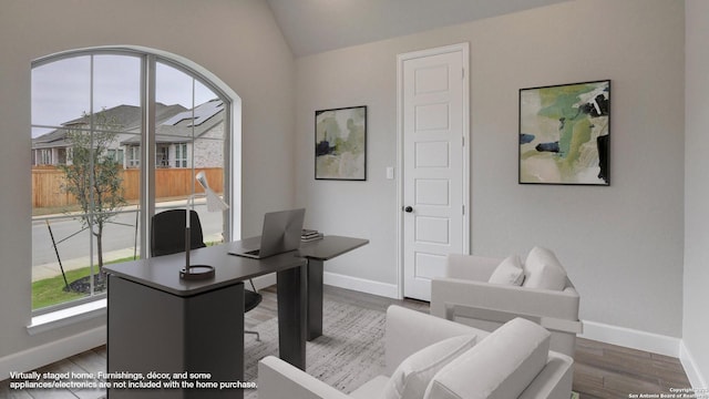 office space with healthy amount of natural light, baseboards, lofted ceiling, and wood finished floors