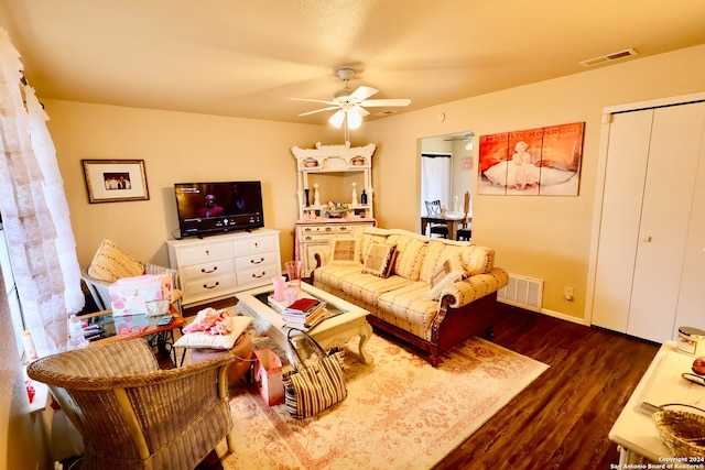 living room featuring ceiling fan and dark hardwood / wood-style floors