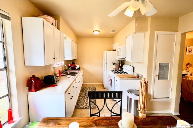 kitchen with sink, light tile patterned flooring, ceiling fan, white cabinetry, and white appliances