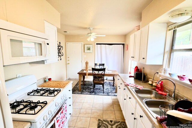 kitchen featuring white appliances, plenty of natural light, white cabinetry, and sink