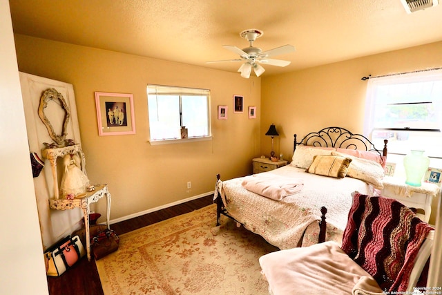 bedroom featuring hardwood / wood-style floors, multiple windows, and ceiling fan