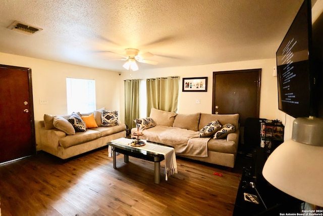 living room featuring hardwood / wood-style flooring, a textured ceiling, and ceiling fan