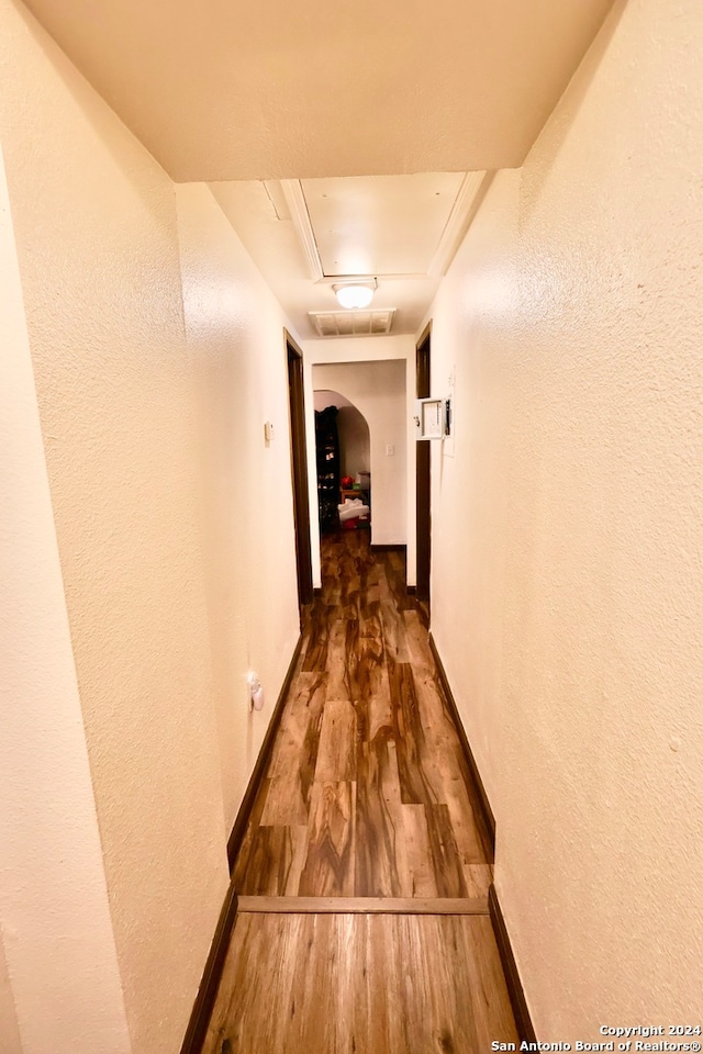 corridor with dark hardwood / wood-style flooring