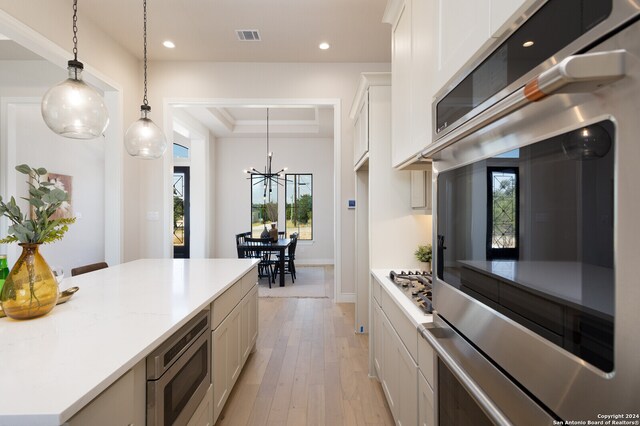 kitchen with pendant lighting, plenty of natural light, white cabinetry, and appliances with stainless steel finishes