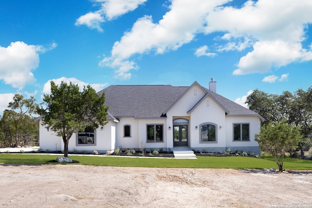 french country inspired facade featuring a front yard