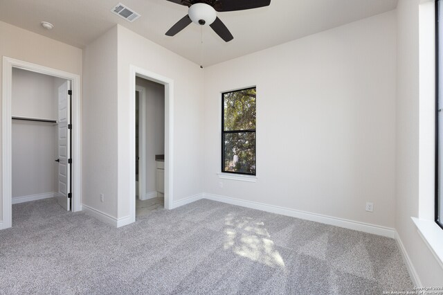 unfurnished bedroom with ceiling fan, light colored carpet, and a closet