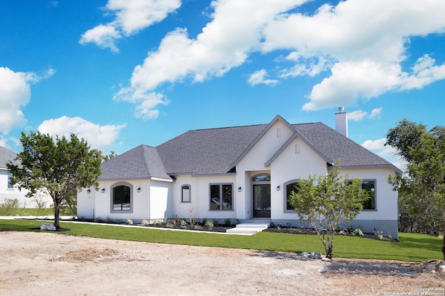 french country inspired facade with a front yard