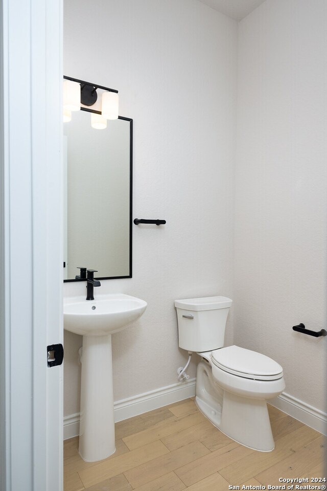 bathroom with toilet and hardwood / wood-style floors