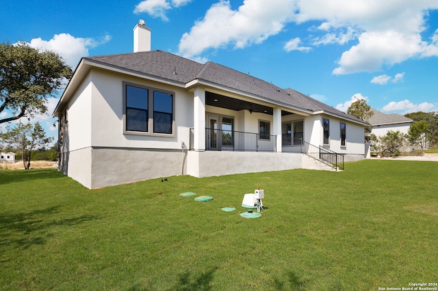 back of house with a patio and a yard