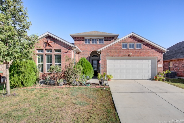 front of property with central AC unit, a garage, and a front lawn