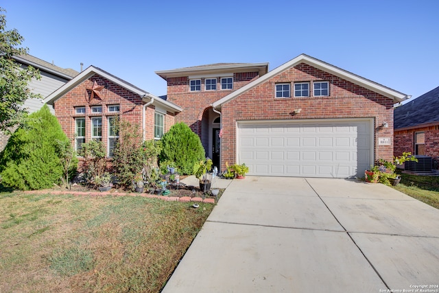 front of property featuring central air condition unit, a garage, and a front yard