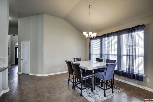 dining area featuring a notable chandelier, dark tile patterned flooring, and vaulted ceiling