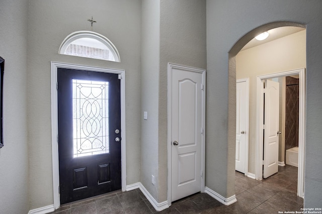 8811 Falcon Park, Converse, TX 78109 - foyer featuring dark tile patterned flooring, arched walkways, a towering ceiling, and baseboards