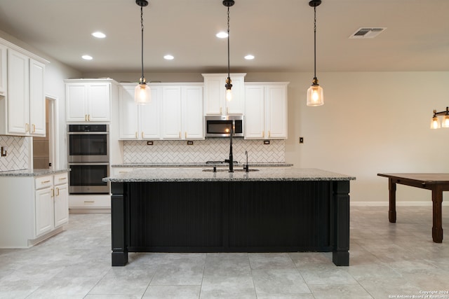 kitchen featuring white cabinets, appliances with stainless steel finishes, and light stone countertops