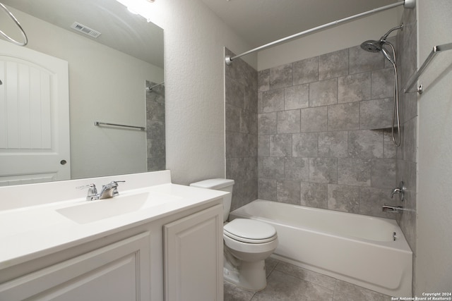 full bathroom with toilet, vanity, tiled shower / bath, and tile patterned floors