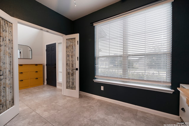 bedroom with french doors and light tile patterned flooring