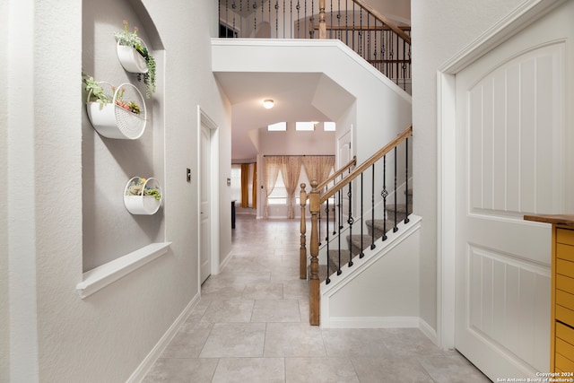 tiled entryway featuring vaulted ceiling