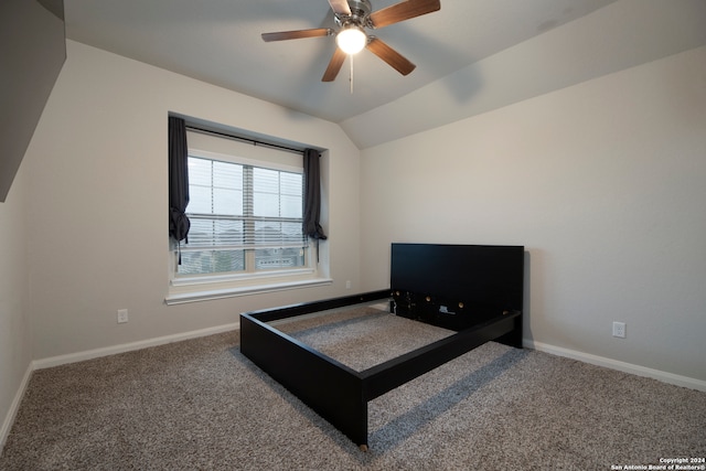 carpeted bedroom with ceiling fan and vaulted ceiling