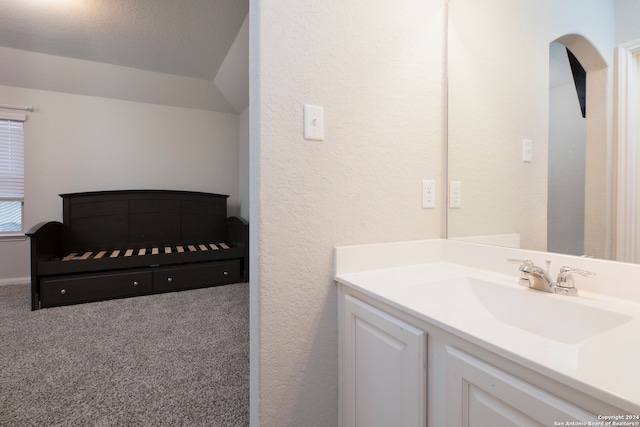 bathroom with vanity, a textured ceiling, and vaulted ceiling