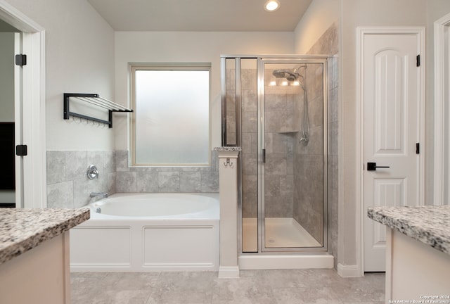 bathroom with tile patterned flooring, vanity, and separate shower and tub