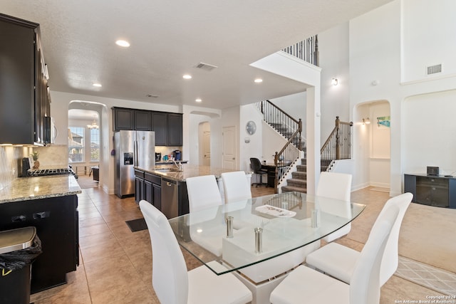 tiled dining room with a textured ceiling and sink