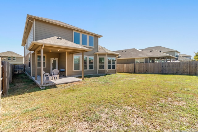 rear view of house featuring a lawn and a patio