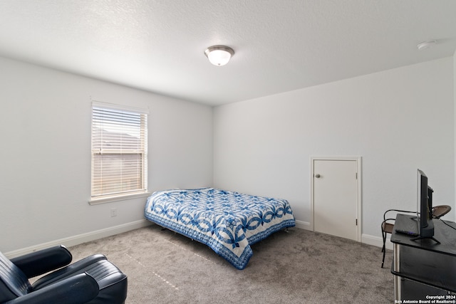 bedroom with light colored carpet and a textured ceiling