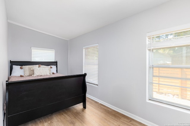 bedroom featuring light hardwood / wood-style floors and lofted ceiling