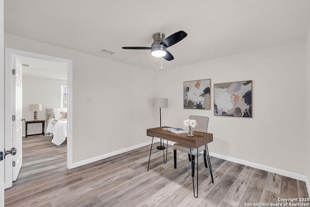 home office featuring ceiling fan and light hardwood / wood-style flooring