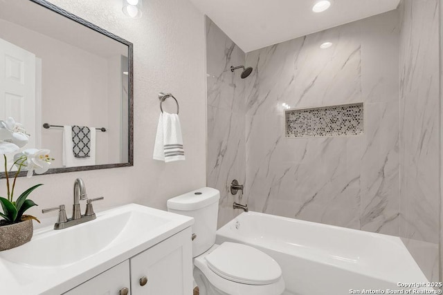 full bathroom featuring vanity, tiled shower / bath combo, and toilet