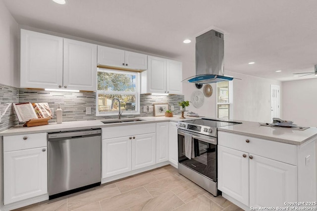 kitchen featuring island exhaust hood, kitchen peninsula, stainless steel appliances, sink, and white cabinets