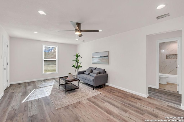 living room with ceiling fan and light hardwood / wood-style floors