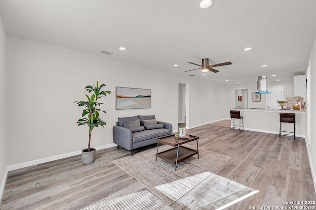 living room with light hardwood / wood-style floors and ceiling fan