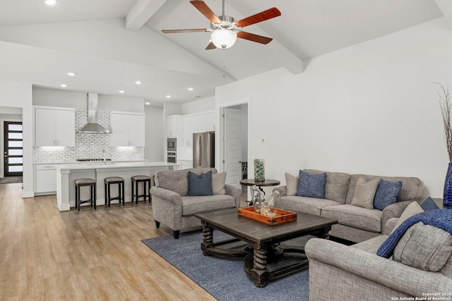 living room featuring ceiling fan, beamed ceiling, light hardwood / wood-style flooring, and high vaulted ceiling