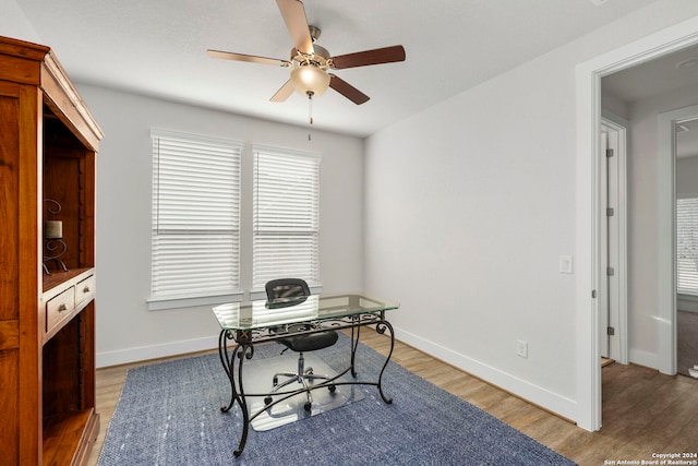 home office with wood-type flooring and ceiling fan