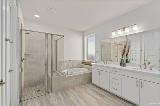 bathroom featuring vanity and independent shower and bath