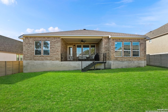 back of property featuring a yard and ceiling fan