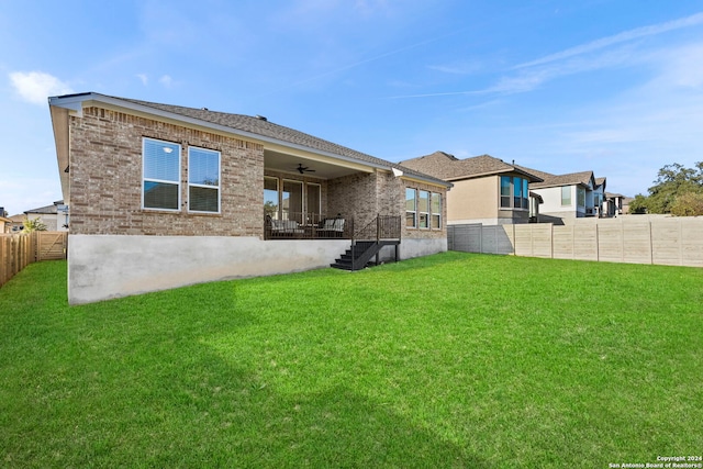 back of property with a lawn and ceiling fan