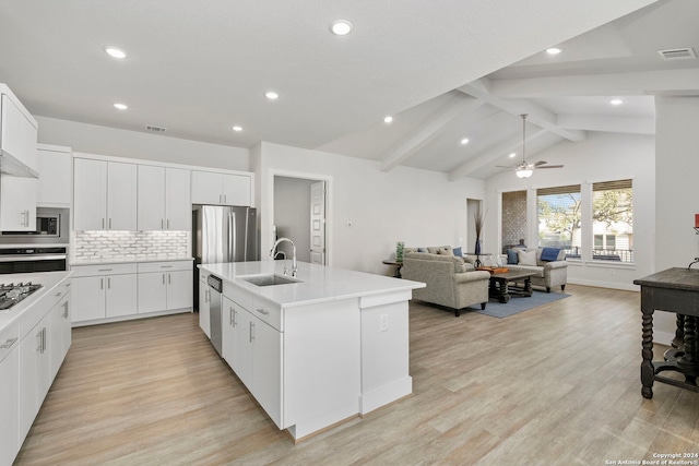 kitchen featuring white cabinetry, sink, an island with sink, light hardwood / wood-style flooring, and lofted ceiling with beams