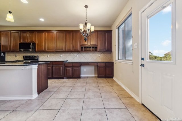 kitchen featuring pendant lighting, appliances with stainless steel finishes, decorative backsplash, and light tile patterned floors