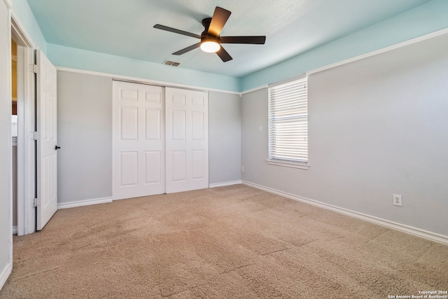 unfurnished bedroom with ceiling fan, a closet, and carpet