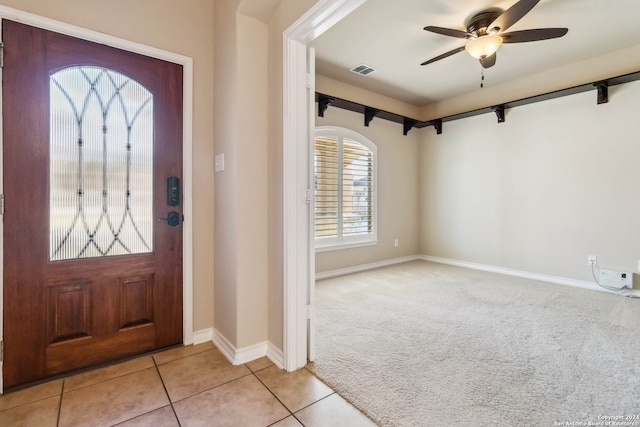 foyer entrance featuring ceiling fan and light colored carpet