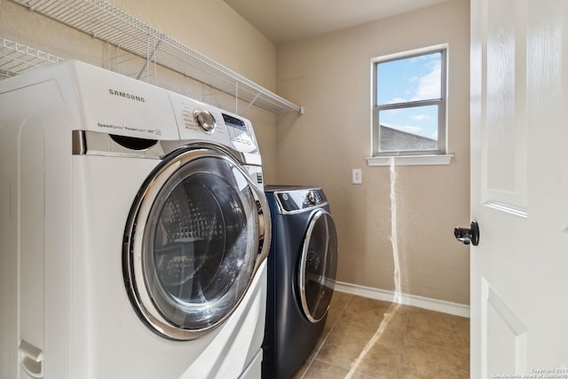 laundry area with washer and dryer and light tile patterned floors